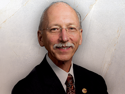 Toastmasters International President Richard Peck posing in suit and tie
