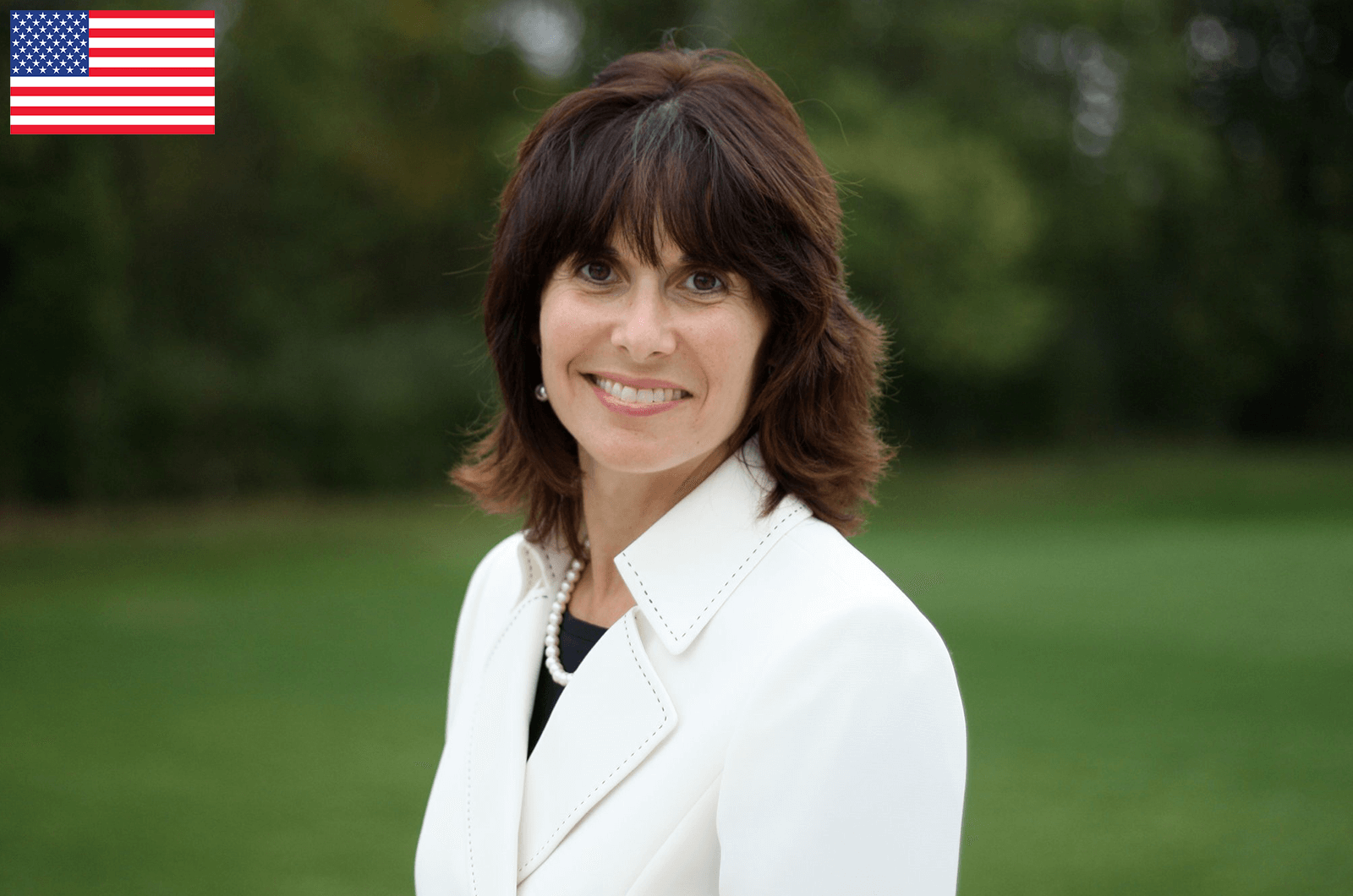 Woman in white jacket smiling at camera