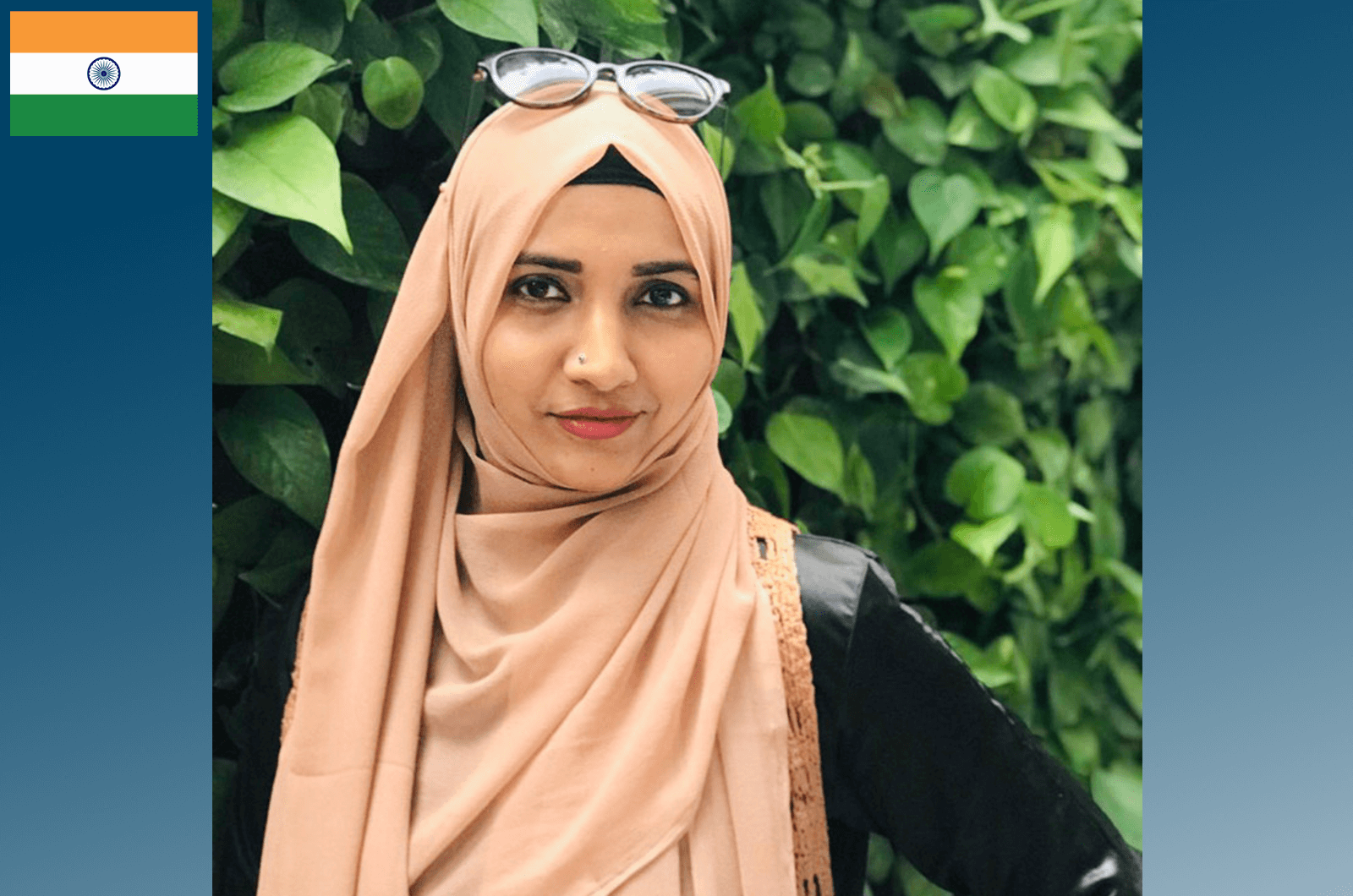 Woman wearing peach-colored hijab with tree in background