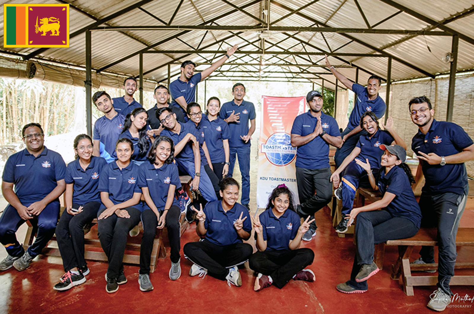 Group of people in blue shirts pose with banner