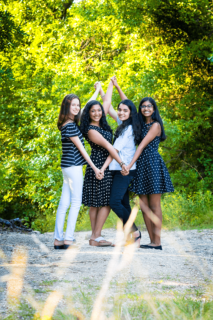 Four girl friends posing outside 