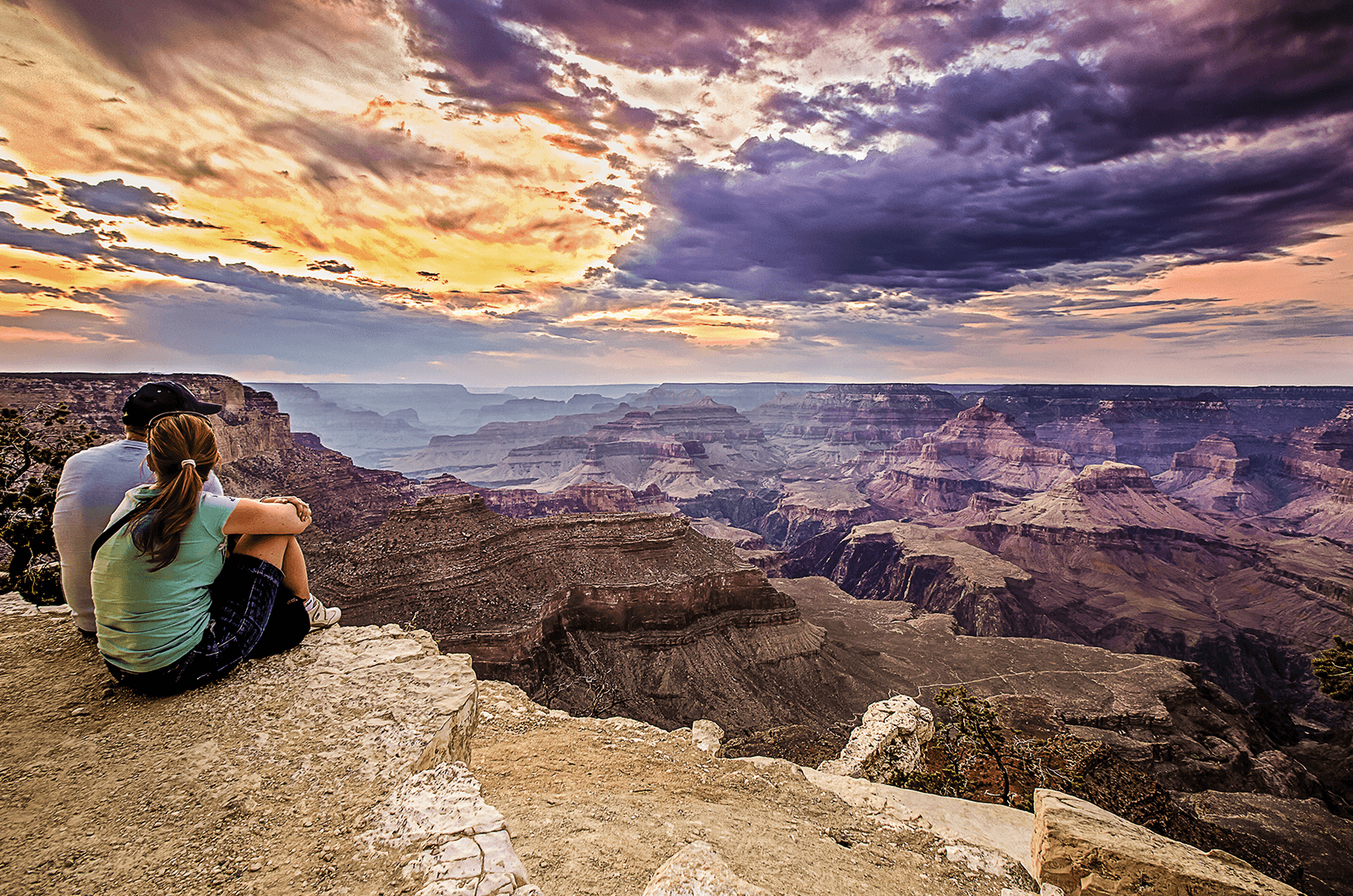 Young man and woman looking at sky at Grand Canyon