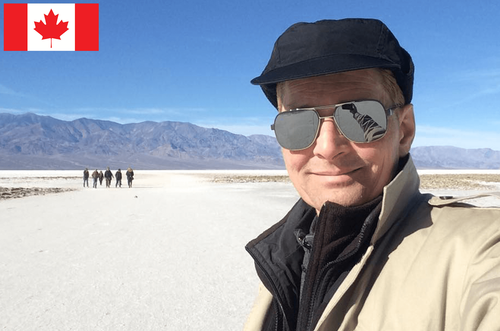 Man posing outdoors wearing hat and sunglasses