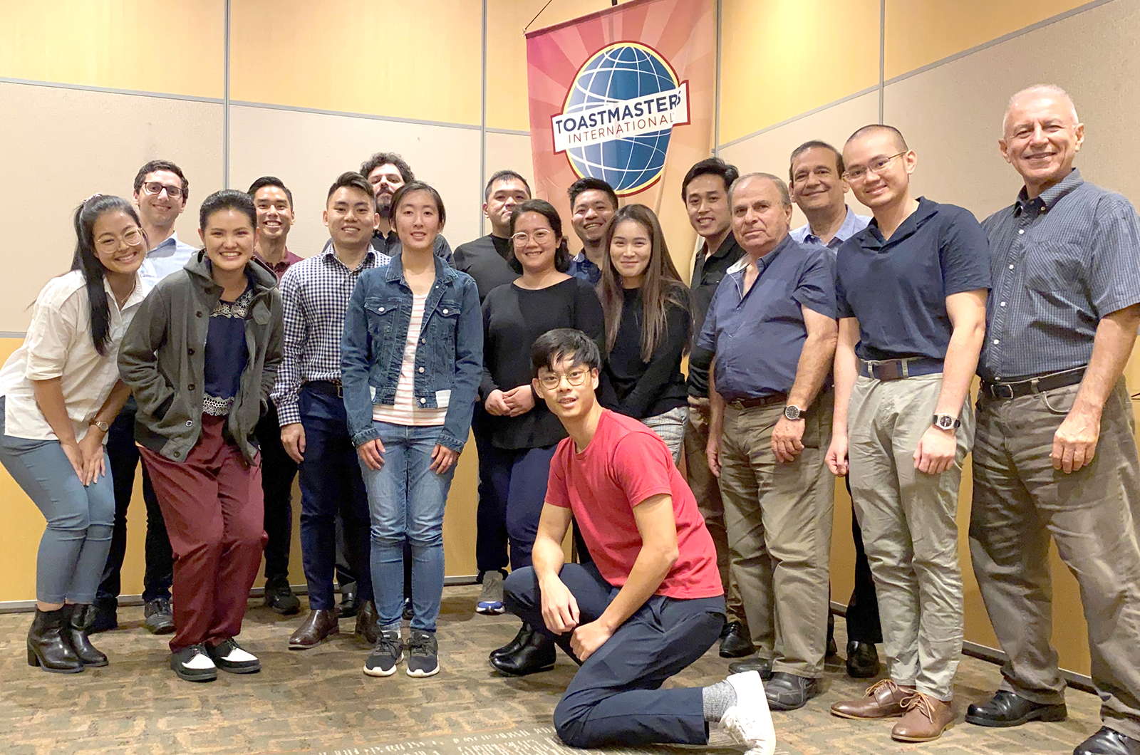 Group of people in blue shirts pose with banner