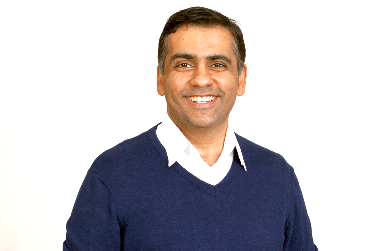 Man in blue sweater standing and smiling