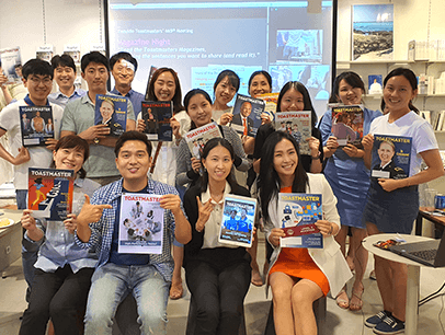 Group of people posing with Toastmaster magazines