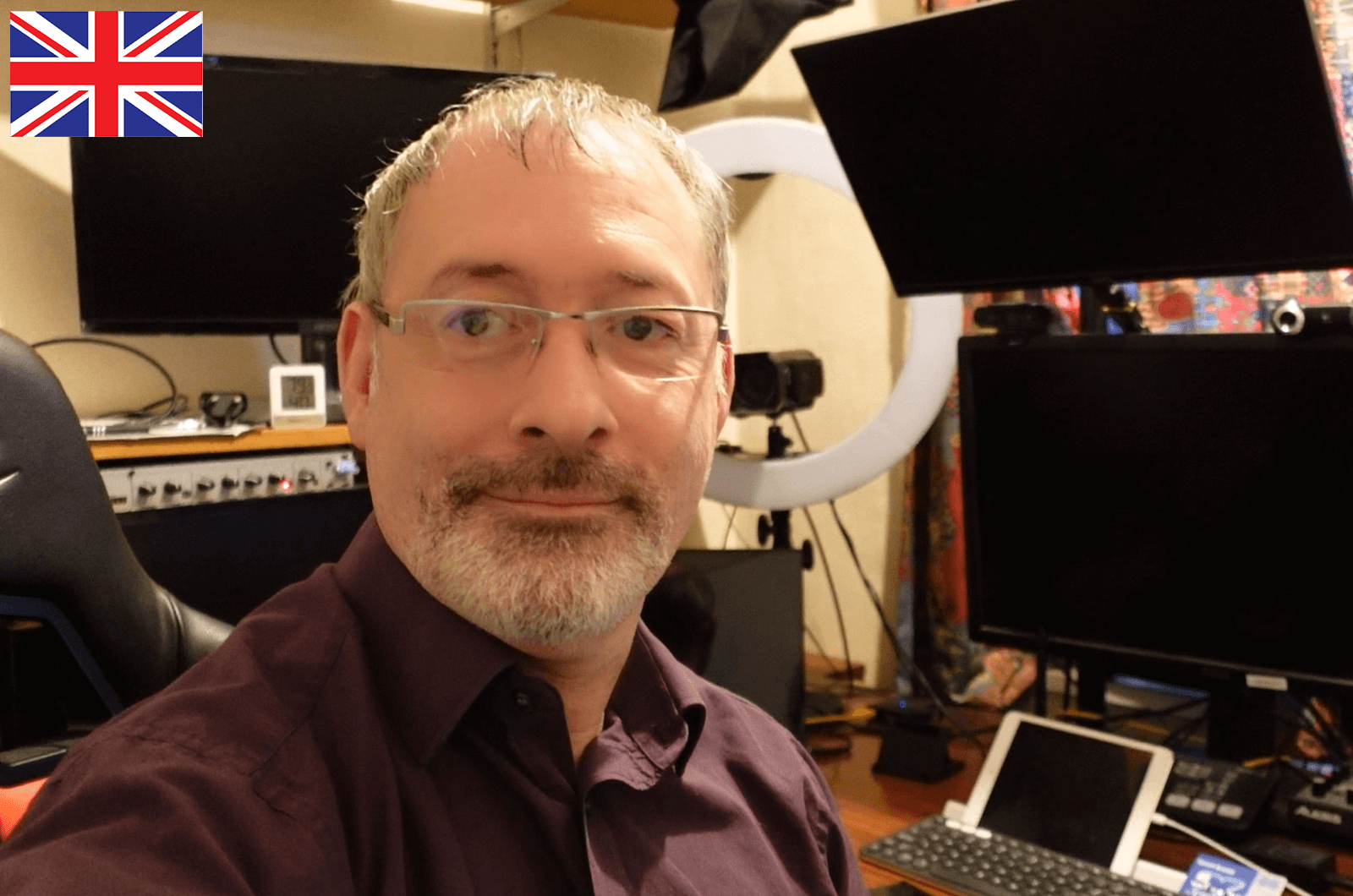 Man looking at camera with computer screens in background