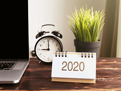 Desk with laptop, clock, calendar, and plant