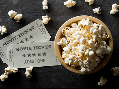 Two movie tickets and bowl of popcorn
