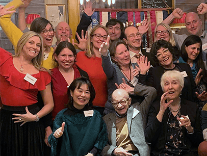 Group of people smiling and celebrating with hands up