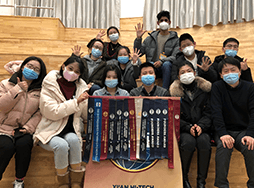 Group of people wearing masks and holding banner