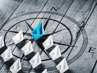 Paper boats on top of compass