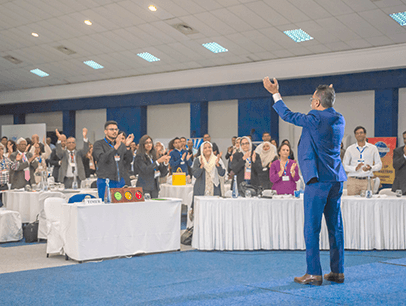 Man in blue suit speaking to audience