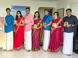 Seven people posing next to banner