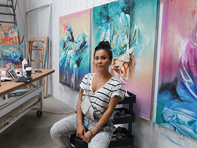 Woman posing in front of wall of art