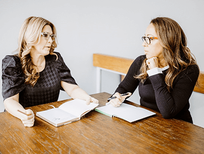 Two women speaking at a table