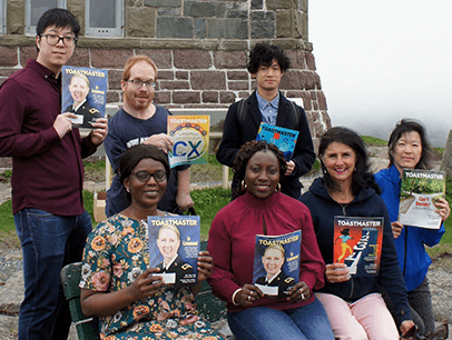 People holding magazines outside