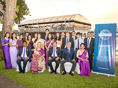Group in purpose outfits posing outdoors with banner