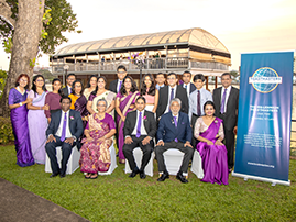 Group in purpose outfits posing outdoors with banner